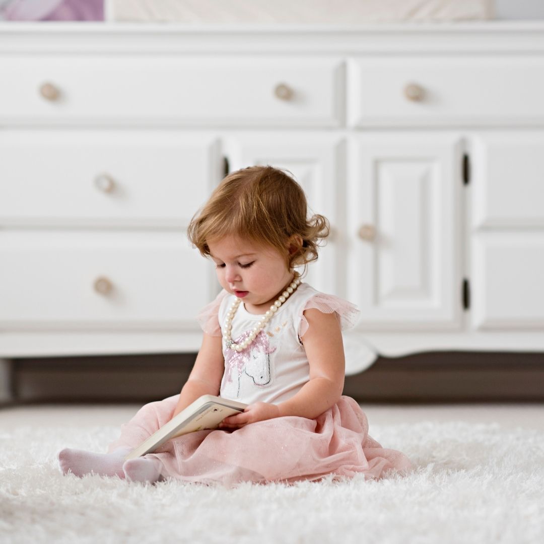white fluffy area rug in bathroom with little girl reading book, design by cynthia soda